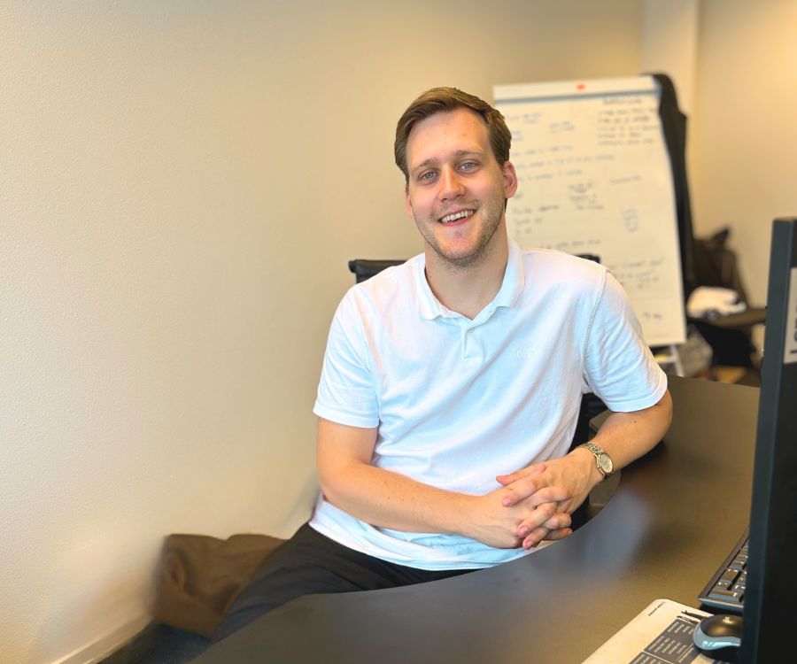 digantfrederik Portræt af Frederik Verner Hansen fra Digant, der smiler ved skrivebordet.